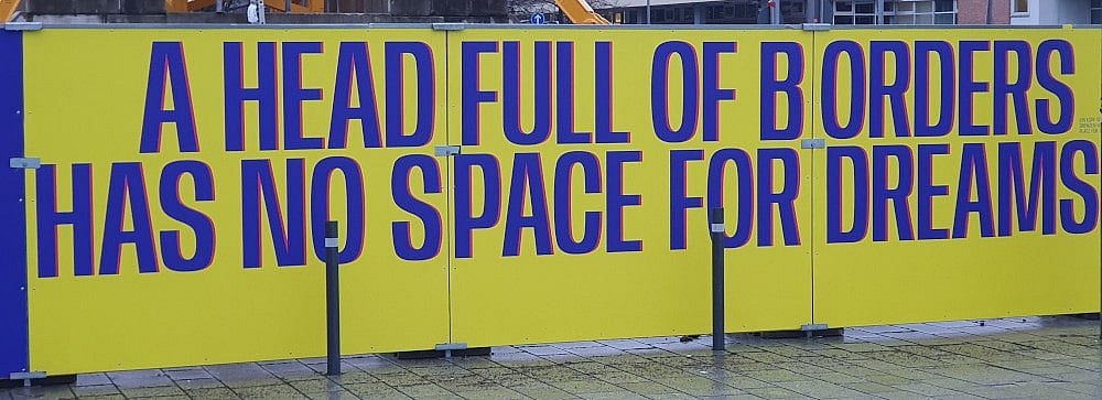 Aufschrift eines Bauzauns in Berlin: Ein Kopf voller Grenzen hat keinen Raum für Träume.