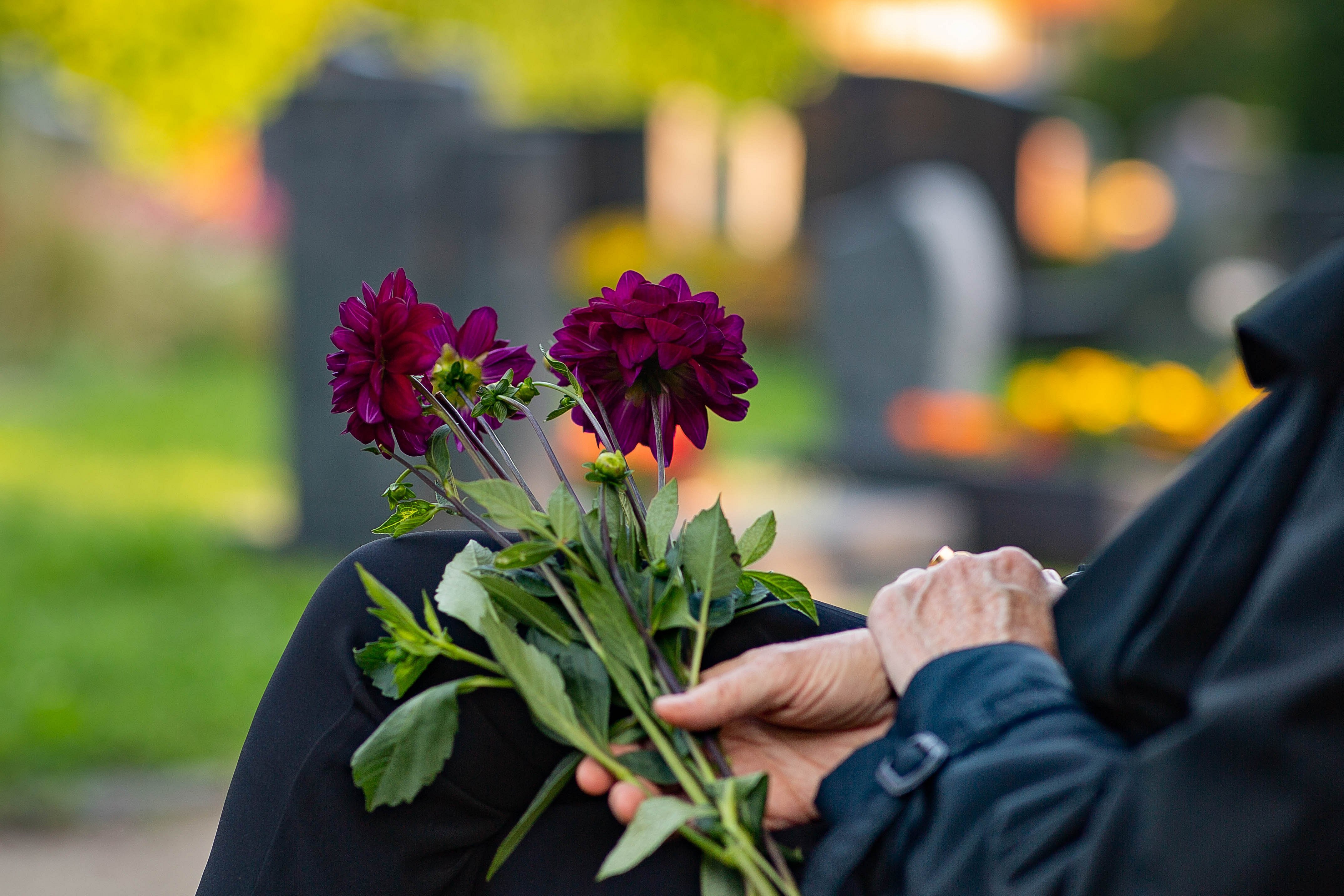 Trauernde Person auf dem Friedhof.