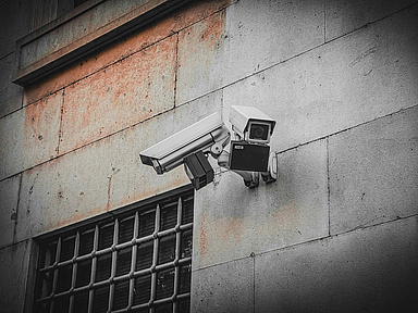 Menschlicher Freiraum ist in modernen Justizvollzugsanstalten kaum zu finden. Kameras und lückenlose Überwachung lassen kaum Raum für Privatsphäre. Unser Symbolbild zeigt Überwachungskameras an einer Gebäudewand. 