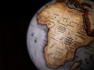 Nahaufnahme eines Globus mit Fokus auf den afrikanischen Kontinent. Deutlich sichtbar sind die Länder Sudan, Tschad, Libyen, Ägypten, Zentralafrikanische Republik, Uganda und Äthiopien. Die Beschriftungen sind in englischer Sprache, die Region Sudan liegt zentral im Bild.