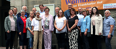 Foto: Bischöfin Dr. Beate Hofmann (Bildmitte) vor dem «Wohnzimmer» des Diakonischen Werks in Homberg
 