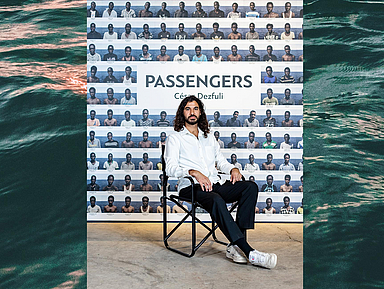 Cesar Dezfuli vor einem Mosaik aus den 118 Bildern, die er 2016 an Bord des zivilen Seenotrettungsschiffes Iuventa gemacht hat.