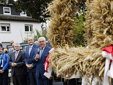 Die rund einen Meter hohe und einen Meter breite Krone steht auf einem Gestell und besteht aus geflochtenen Ähren von Weizen, Roggen und Hafer. Steinmeier (r.) nahm auch an einem ökumenischen Erntedankgottesdienst in der Kirche St. Martin teil.