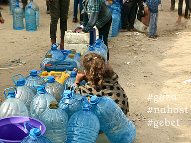 Ein Mädchen hockt zwischen leeren Kanistern in einer Schlange von Menschen, die auf frisches Trinkwasser warten. 
