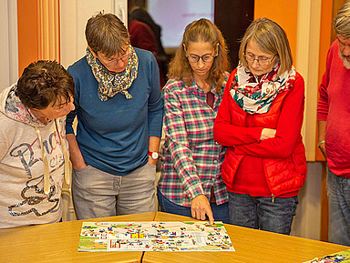 Die Teilnehmenden stellten sich keinem einfachen Thema. Unser Foto zeigt die Männer und Frauen beim Diskutieren über Situationen mit Kindern und Jugendlichen. Hilfestellung gaben dabei Wimmelbilder voller Figuren und Details. (Foto: medio.tv/Dellit)