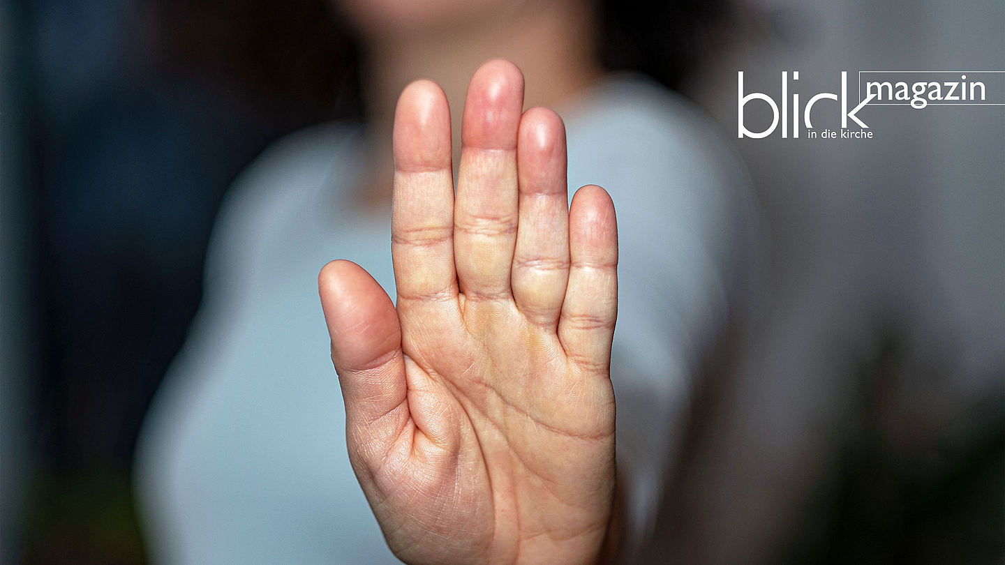 Frau, die mit ihrer Hand zu verstehen gibt: Stopp, hier nicht weiter!