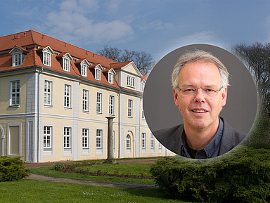 Porträt von Dr. Lutz Friedrichs, Direktor des Evangelischen Studienseminars der EKKW, vor dem historischen Gebäude „Friedrichsbad“ im Park des Gesundbrunnens in Hofgeismar.