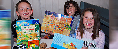Lennox Bulst, Valentina Görke und Hanna-Marie Volz (v.l.) freuen sich stellvertretend für alle Kids in der Ulfener Kirchengemeinde sehr über die neue spannende Lektüre. (Foto: Matthias Siegk)