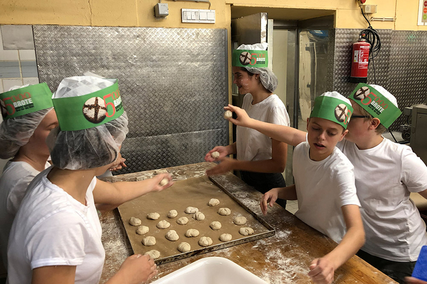 Konfirmandinnen und Konfirmanden backen in einer Bäckerei (Foto: ZGV)