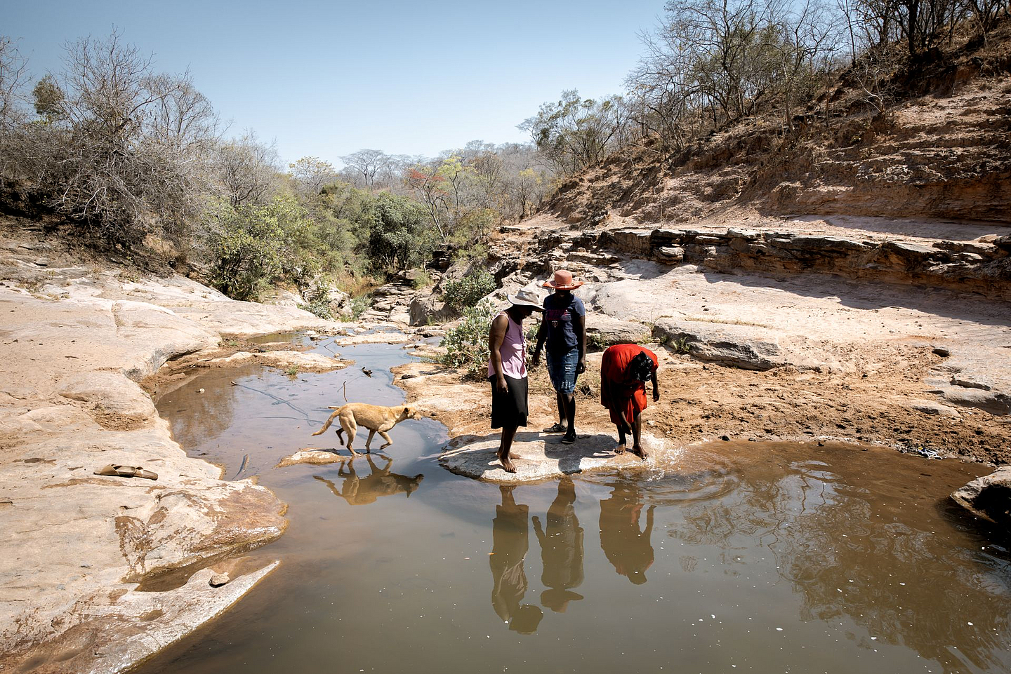 Die Freundinnen Beauty Nyathi (45), Gracious Mujuma (42) und Sihle Hahlani (31) am Fluss Chiurayi. Hier haben sie früher Wasser geholt. Durch MeDRAs Arbeit (BfdW-Partnerorganisation) hat sich ihr Leben sehr verbessert. Sie lernen und unterstützen sich gegenseitig.