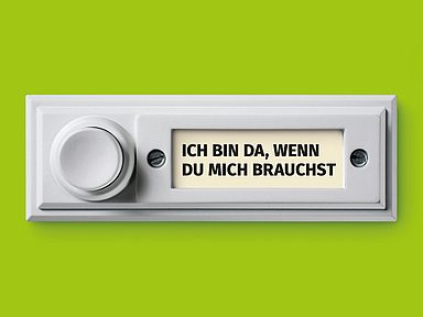 Das Bild zeigt eine weiße Türklingel vor grünem Hintergrund. Auf dem Namensschild der Klingel steht in Großbuchstaben: «ICH BIN DA, WENN DU MICH BRAUCHST».