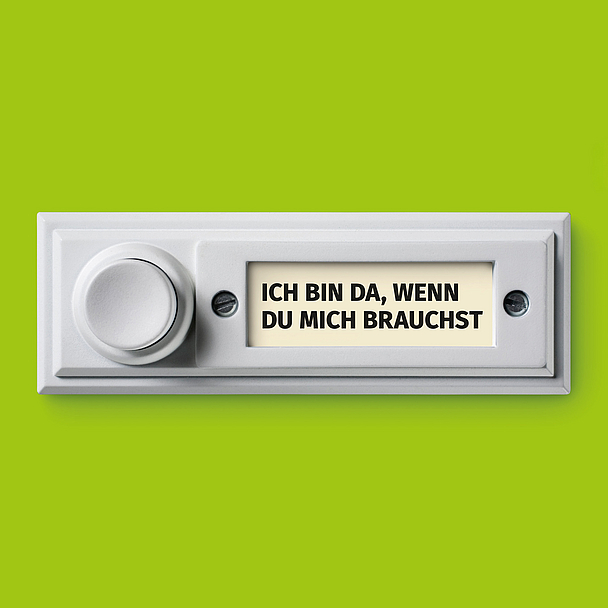 Das Bild zeigt eine weiße Türklingel vor grünem Hintergrund. Auf dem Namensschild der Klingel steht in Großbuchstaben: «ICH BIN DA, WENN DU MICH BRAUCHST».