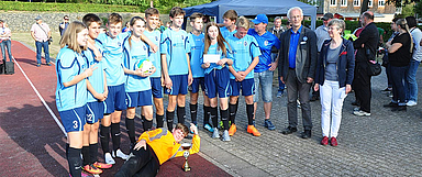 Pfarrerin Katja Friedrichs-Warnke (r.) von der Konfirmanden-Arbeit der Landeskirche und Dekan Christian Wachter (2.v.r) überreichten den Konficup-Pokal an die siegreiche Mannschaft aus Heringen. (Foto-Quelle: medio.tv/Glitzenhirn)
