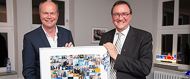Medienhausleiter Pfarrer Christian Fischer (l.) überreichte Bischof Hein eine Fotocollage mit Motiven aus 39 Chats, verbunden mit dem Dank für «39 bewegende, bisweilen aufregende, immer aber unterhaltsame Online-Gespräche». (Foto: medio.tv/Schauderna)