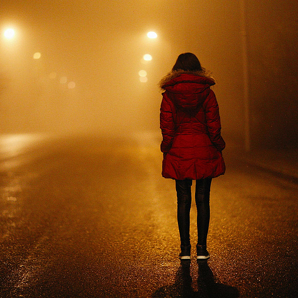 Unser Foto zeigt eine Frau auf einer düsteren Straße