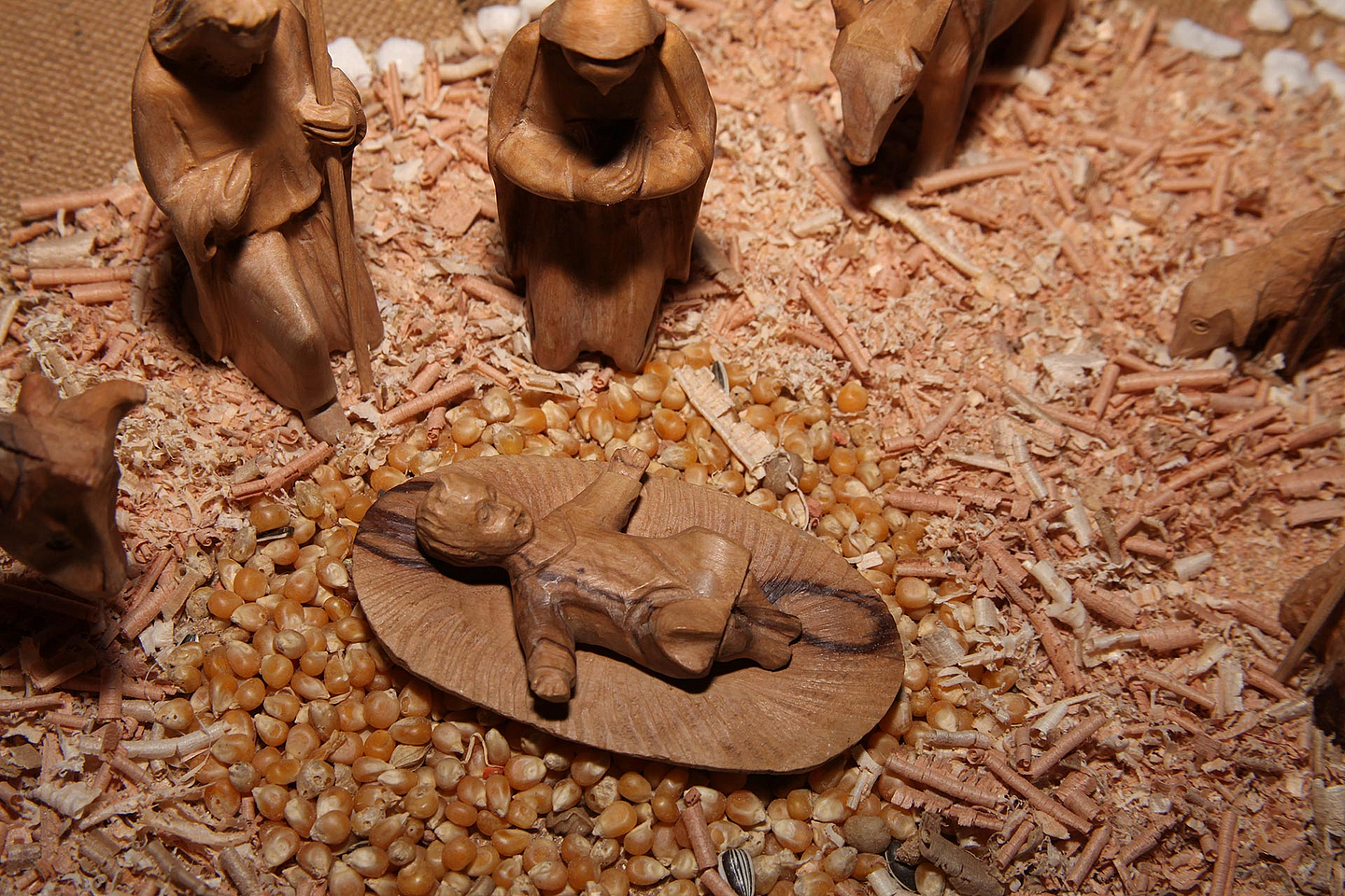 Unser Foto zeigt eine aus Holz geschnitzte Darstellung des Jesuskindes in einer Krippe. 