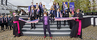 Spannten zum Abschluss des 3. ÖKT in Frankfurt ein ökumenisches Band: Bischöfin Beate Hofmann (Mitte), Bischof Michael Gerber (r.) und Weihbischof Karlheinz Diez (l., beide Bistum Fulda). Hofmann und Gerber gestalteten eine gemeinsame Bibelarbeit. Das Foto entstand am Rande des Abschlussgottesdienstes. Im Hintergrund sind Sängerinnen und Sänger des JugendKathedralChors Fulda zu sehen, die den Gottesdienst musikalisch mitgestalteten. (Foto: ÖKT/Philip Wilson)
