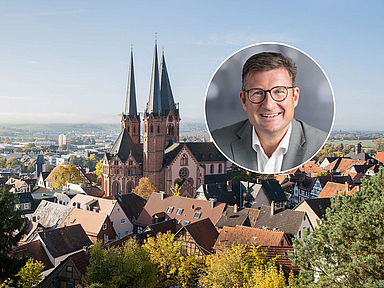 Unser Foto zeigt Pfarrer Marvin Lange. Im Hintergrund sieht man Gelnhausen mit der markanten Marienkirche. In der Stadt befindet sich das Dekanat des Kirchenkreises. 