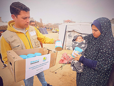 Ein Mitarbeiter der Hilfsorganisation verteilt Dosenmilch für Neugeborene und Kleinkinder in einem Flüchtlingscamp in Rafah im südlichen Gazastreifen.