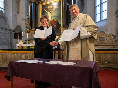 Bischöfin Dr. Beate Hofmann und Erzbischof Urmas Viilma mit der unterzeichneten Partnerschaftsvereinbarung im Tallinner Dom.
