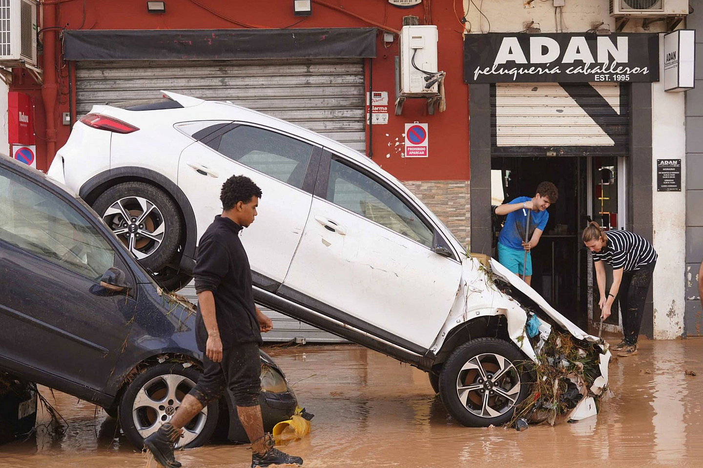 Zwei Autos stehen ineinander gekeilt durch ein Hochwasser 2024 auf einer Straße in Valencia in Spanien 