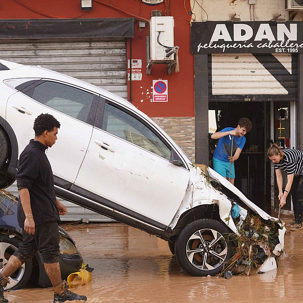 Zwei Autos stehen ineinander gekeilt durch ein Hochwasser 2024 auf einer Straße in Valencia in Spanien 