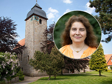 Das Foto zeigt die romanische Klosterkirche in Germerode, eingebettet in eine grüne Umgebung. Ein Weg führt auf das historische Gebäude zu. In einem runden Ausschnitt oben rechts ist Pfarrerin Sissy Maibaum abgebildet, die seit August 2025 die Pfarrstelle für Spiritualität und geistliches Leben der EKKW innehat.