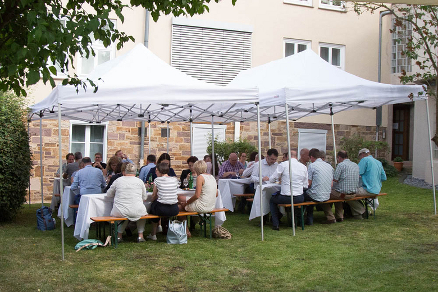 Auf Bänken und nicht zwischen den Stühlen: Im Anschluss an den Vortrag nutzten die Besucher die Chance, sich im Garten bei Speisen vom Grill und kühlen Getränken auszutauschen.