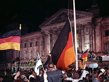 Feier der Wiedervereinigung 1990 in Berlin Hunderttausende waren am 3. Oktober 1990 dabei, als vor dem Reichstags-Gebäude in Berlin die deutsche Wiedervereinigung gefeiert wurde. Unser Foto zeigt , wie dort an dem Tag die schwarz-rot-goldene Bundesfahne gehißt wurde.