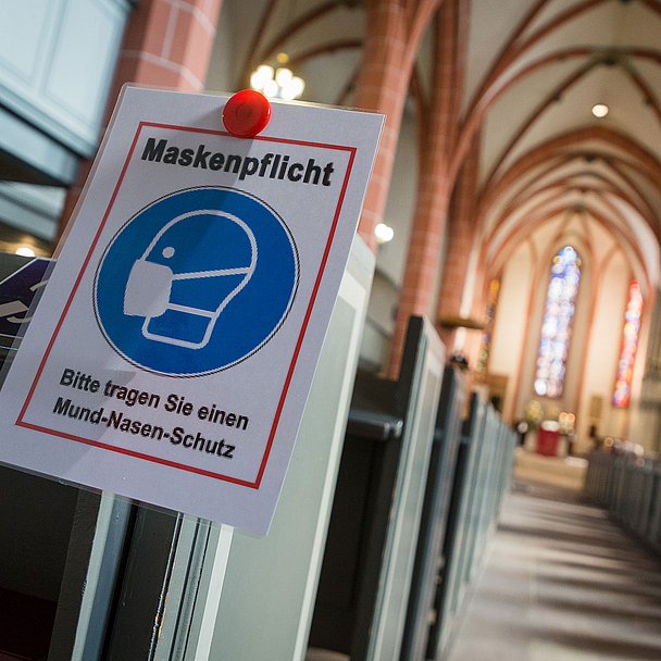 Unser Foto zeigt den Hinweis auf die Maskenpflicht in einer Kirche während der Pandemie.