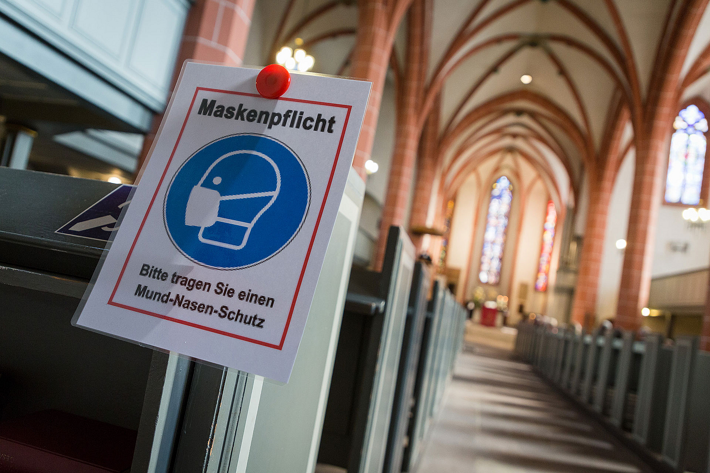 Unser Foto zeigt den Hinweis auf die Maskenpflicht in einer Kirche während der Pandemie.