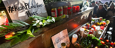 Viele Menschen kamen am Donnerstagabend auf dem Hanauer Marktplatz zusammen, um den Opfern der Gewalttat zu gedenken und zusammenzustehen. Unser Foto zeigt Kerzen und Blumen, die Menschen am Brüder-Grimm-Nationaldenkmal abgelegt haben. (Foto: medio.tv/Schauderna)