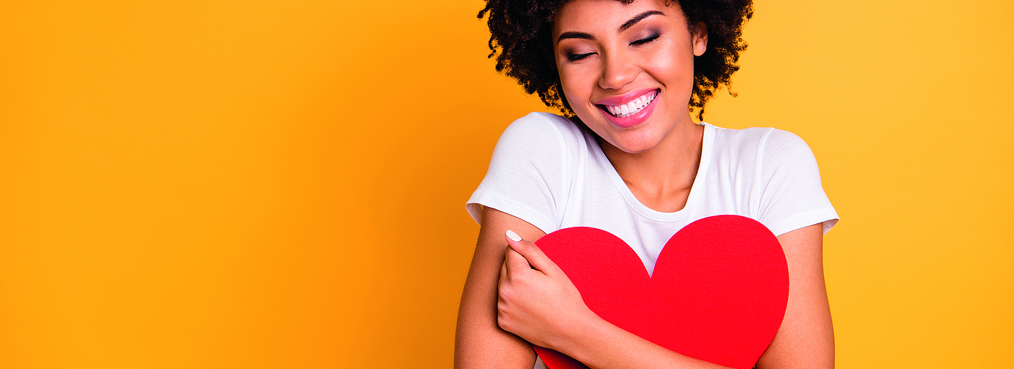 Close up photo beautiful amazing she her dark skin lady adorable remember cuddle big paper card heart shape figure form dreamy wear casual white t-shirt isolated yellow bright vibrant background