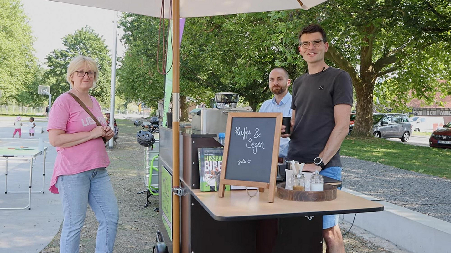 Anlaufpunkt Freizeit- und Skate-Anlage am Melsunger Fulda-Ufer (v.r.): Pfarrer Henning Meinecke und Tobi Jäger mit einer Besucherin der Fahrrad-Kirche.

