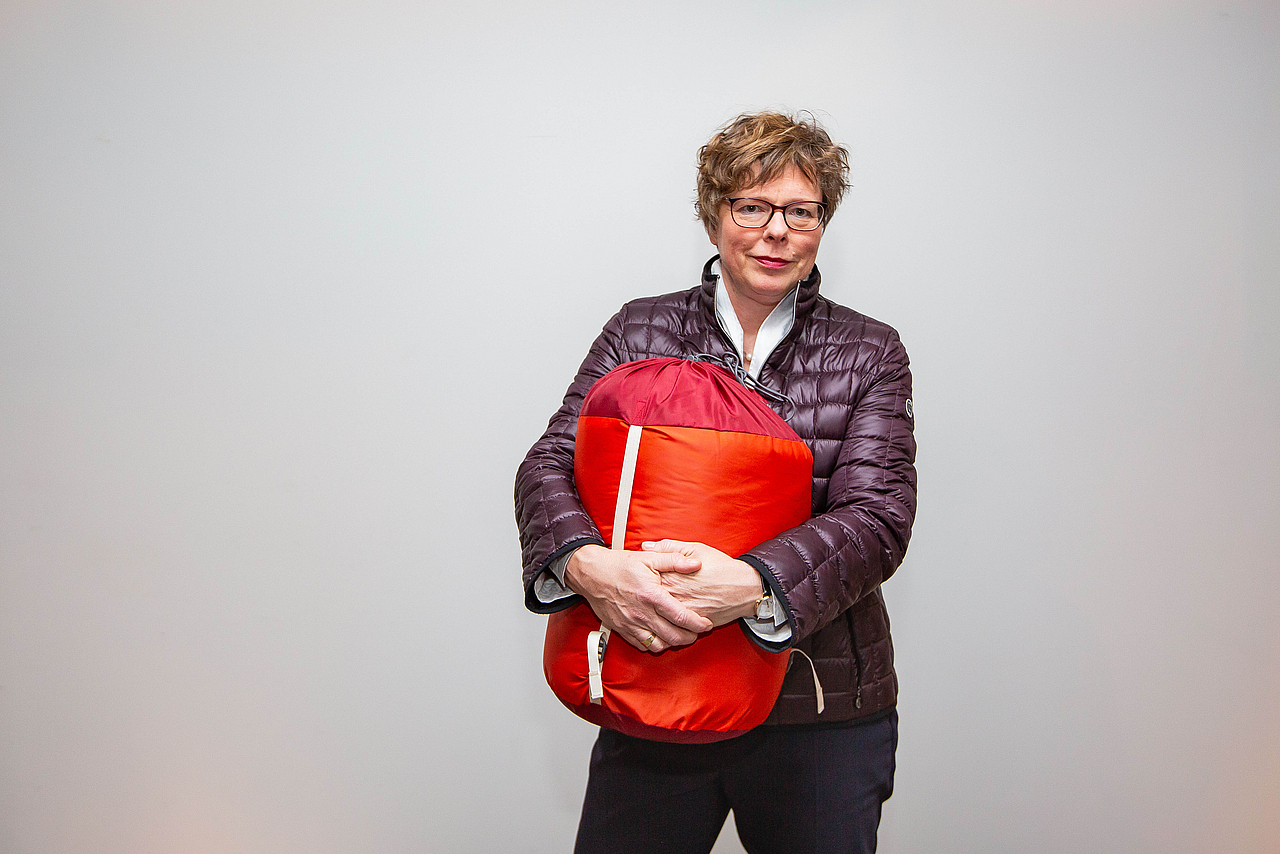 Das Foto zeigt Bischöfin Dr. Beate Hofmann mit einem Schlafsack im Arm.