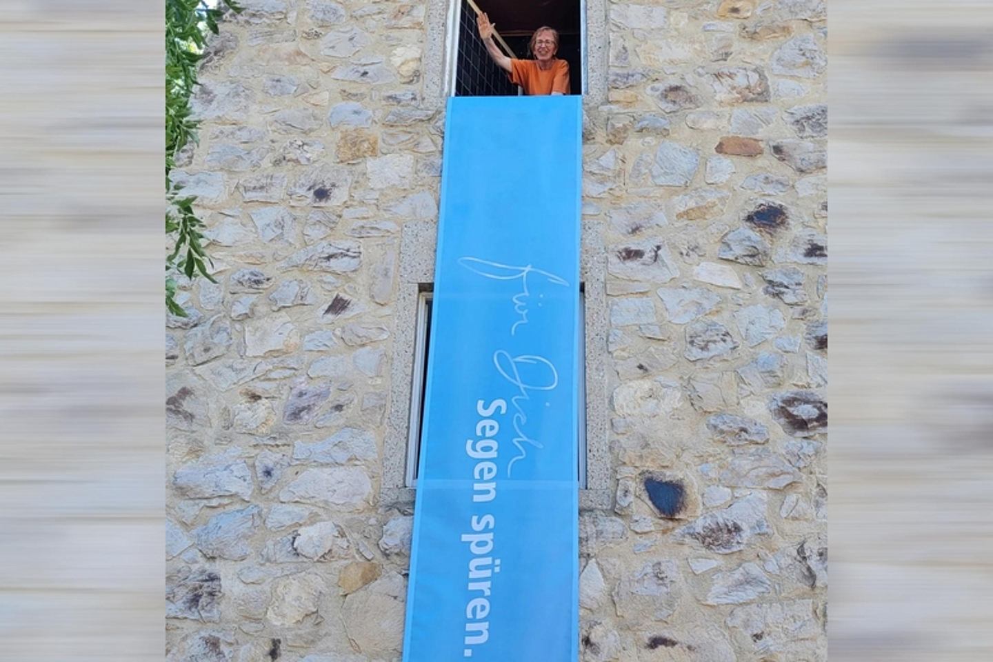 Am Turm der Neuen Johanneskirche kündigte ein großes Banner die Taufaktion an. Pfarrerin Margin Zahn (winkend) freute sich mit Ihren Kolleginnen und Kollegen sehr auf die Taufen.