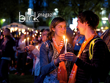 Menschen im Kerzenschein beim Kirchentag 2017 in Berlin