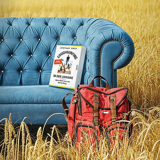 Unser Foto zeigt ein Sofa in einem Kornfeld, vor dem ein Rucksack steht. Auf dem Sofa liegt das Buch des Autors. Daneben ist das Logo des Bündnisses Offen für Vielfalt - Geschlossen gegen Ausgrenzung abgebildet.