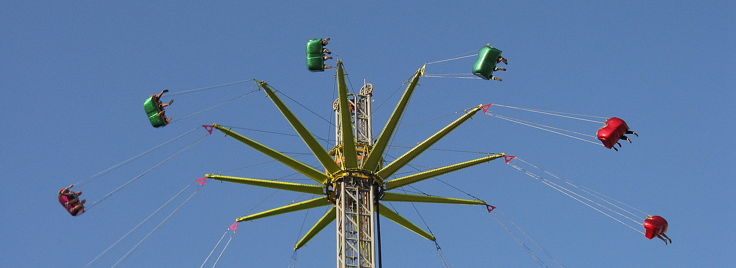 Kettenkarussell mit Fahrenden in großer Höhe vor blauem Himmel. Foto (Ausschnitt): Gaby Bessen, pfarrbriefservice.de Kettenkarussell mit Fahrenden in großer Höhe vor blauem Himmel. Foto (Ausschnitt): Gaby Bessen, pfarrbriefservice.de