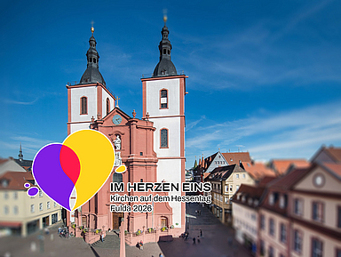 «Im Herzen eins»: Das Hessentagsmotto kommt auch in einem gemeinsamen Logo zum Ausdruck – ein Symbol des Miteinanders. Im Hintergrund ist die Fuldaer Stadtpfarrkirche zu sehen, die während des Hessentags zur multimedial inszenierten Hessentagskirche wird.