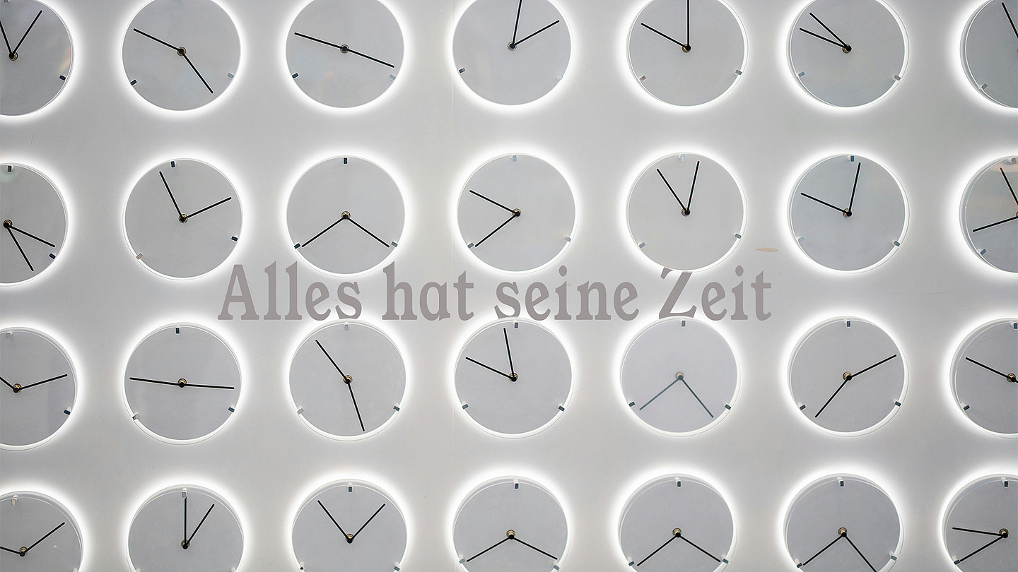 Unser Foto Zeigt eine Wand voller Uhren mit der Aufschrift "Alles hat seine Zeit"