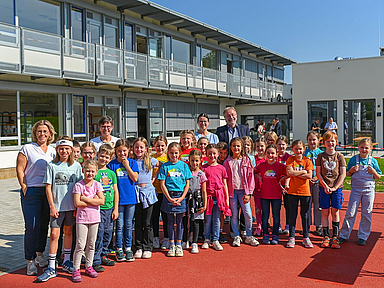 Schülerinnen und Schüler der Katharina-von Bora-Schule mit der Schulleitung und weiteren Gästen vor der neuen Mensa (hinten rechts)