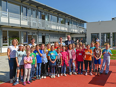 Schülerinnen und Schüler der Katharina-von Bora-Schule mit der Schulleitung und weiteren Gästen vor der neuen Mensa (hinten rechts)