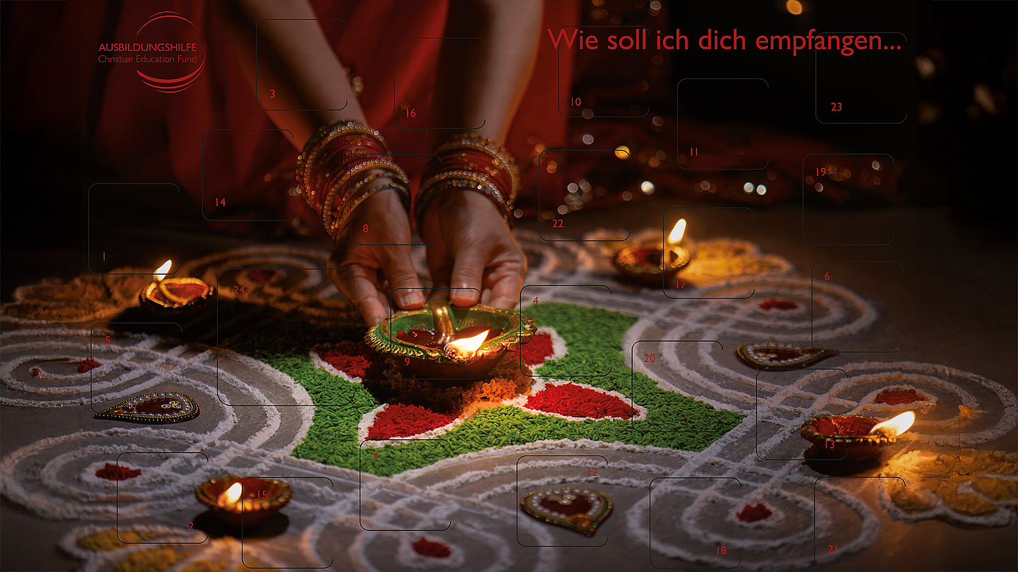 Auf dem Adventskalender der Ausbildungshilfe ist ein buntes Rangoli, ein gestreuter Willkommensgruß aus gefärbten Reiskörnern, zu sehen. 