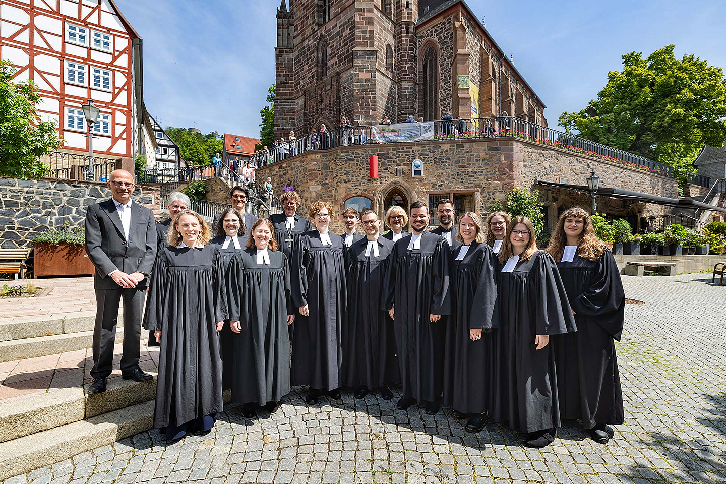 Gruppenfoto vor der Homberger Stadtkirche Die 10 frisch ordinierten Pfarrerinnen und Pfarrer mit (1.R.v.l.): Pfarrerin Jana Koch-Zeißig , Studienleiterin Johanna Fischer, Studienseminardirektorin Dr. Regina Sommer, (2.R.v.l.): Kirchenvorsteher Dr. Jürgen Helm, Pfarrerin Anke Zimmermann (Homberg/Efze), Studienleiter Thomas Hof und Bischöfin Dr. Beate Hofmann vor der Homberger Stadtkirche