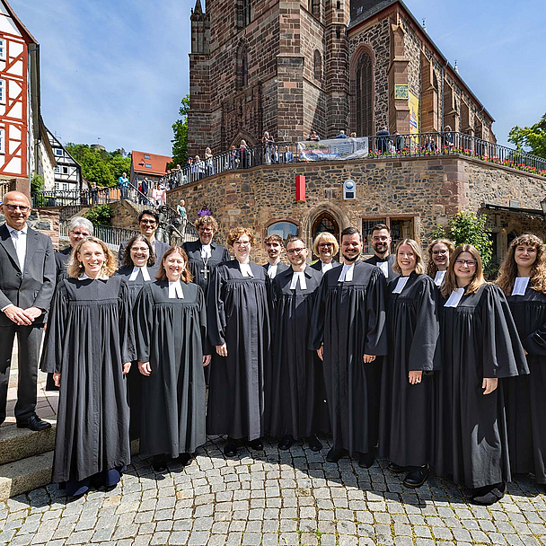 Gruppenfoto vor der Homberger Stadtkirche Die 10 frisch ordinierten Pfarrerinnen und Pfarrer mit (1.R.v.l.): Pfarrerin Jana Koch-Zeißig , Studienleiterin Johanna Fischer, Studienseminardirektorin Dr. Regina Sommer, (2.R.v.l.): Kirchenvorsteher Dr. Jürgen Helm, Pfarrerin Anke Zimmermann (Homberg/Efze), Studienleiter Thomas Hof und Bischöfin Dr. Beate Hofmann vor der Homberger Stadtkirche