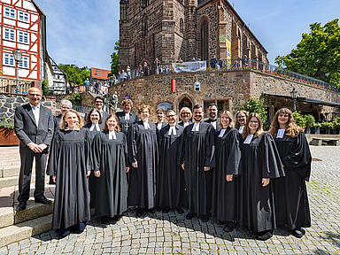 Die 10 frisch ordinierten Pfarrerinnen und Pfarrer mit (1.R.v.l.): Pfarrerin Jana Koch-Zeißig , Studienleiterin Johanna Fischer, Studienseminardirektorin Dr. Regina Sommer, (2.R.v.l.): Kirchenvorsteher Dr. Jürgen Helm, Pfarrerin Anke Zimmermann (Homberg/Efze), Studienleiter Thomas Hof und Bischöfin Dr. Beate Hofmann vor der Homberger Stadtkirche