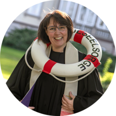 Das Foto zeigt Kerstin Palisaar im Talar mit einem Rettungsring mit der Aufschrift Schulseelsorge Das Foto zeigt Kerstin Palisaar im Talar mit einem Rettungsring mit der Aufschrift Schulseelsorge