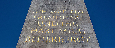 Das rund 16 Meter hohe Kunstwerk trägt auf einer Seite als Aufschrift das Bibelzitat «Ich war ein Fremdling und ihr habt mich beherbergt». Die anderen drei Seiten zitieren den Spruch auf Arabisch, Türkisch und Englisch. (Foto: medio.tv/Schauderna)