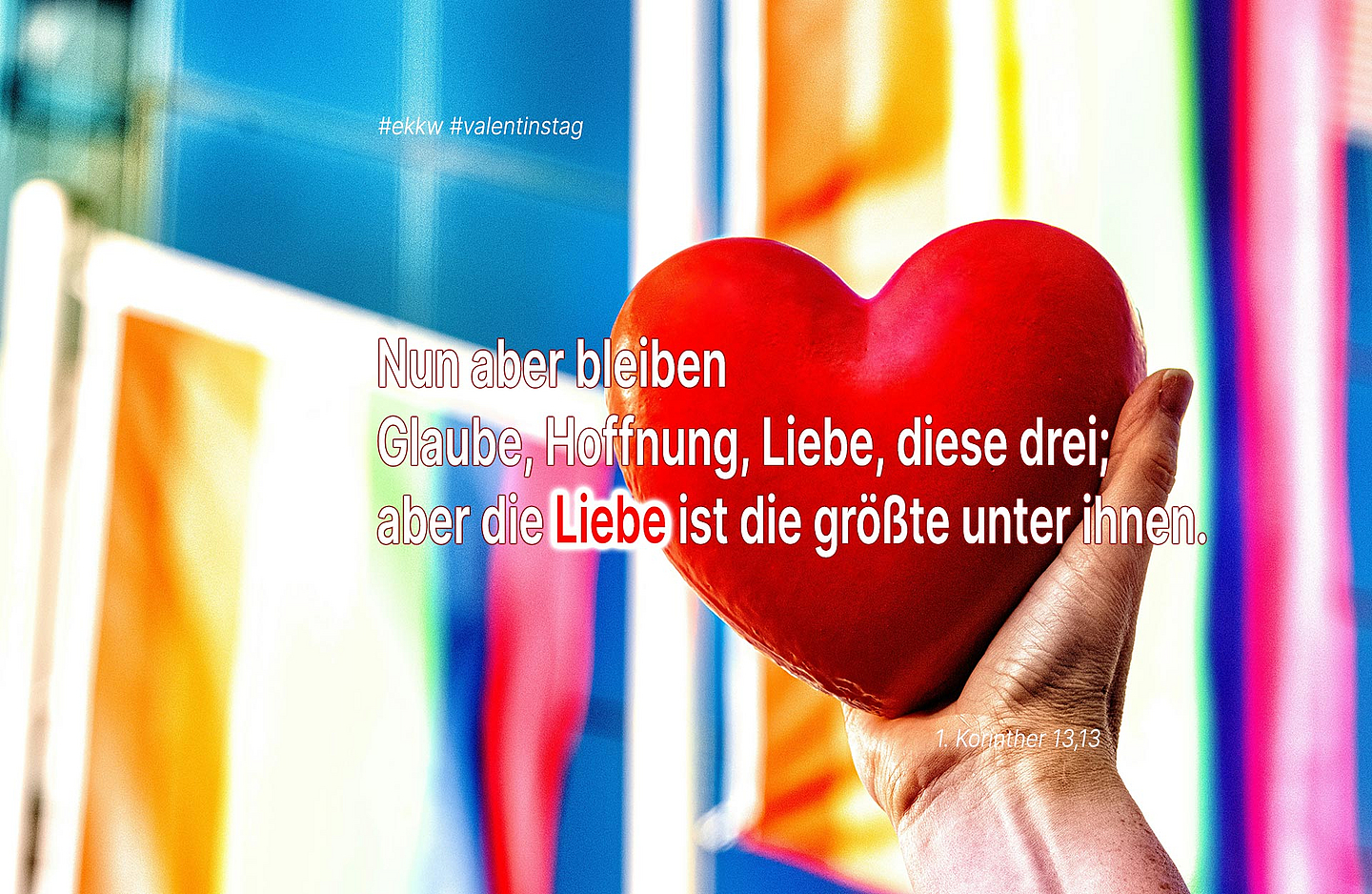 Ein Herz zeigt den bekannten Bibelvers aus dem Hohelied der Liebe: Nun aber bleiben Glaube, Hoffnung, Liebe, diese drei; aber die Liebe ist die größte unter ihnen. (1. Korinther 13,13)